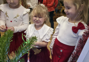 Dziewczynki ubierają choinkę.