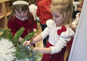 Dzieci ubierają choinkę.