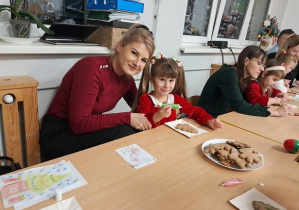 Dziewczynka z mamą ozdabiają pierniczki.