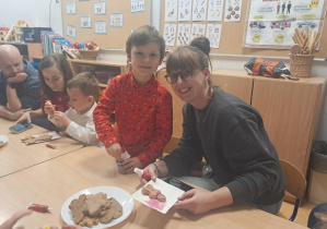 Chłopiec z mamą ozdabia pierniczki.