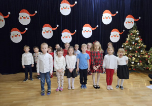 Dzieci na scenie na tle świątecznej dekoracji