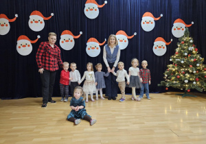 Dzieci na scenie na tle świątecznej dekoracji