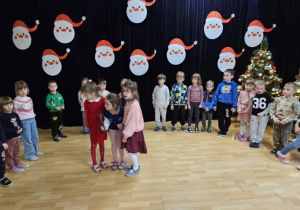 Dzieci na scenie na tle świątecznej dekoracji