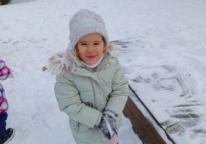 Dziewczynka bawi się śniegiem.