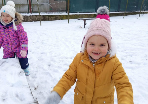 Dziewczynka bawi się śniegiem.