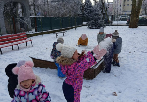 Dziewczynka rzuca śnieg.