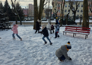 Dzieci lepią kule ze śniegu.