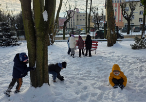 Dzieci rzucają się śnieżkami.