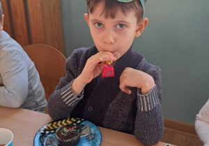 chłopiec dmucha przez gwizdek urodzinowy