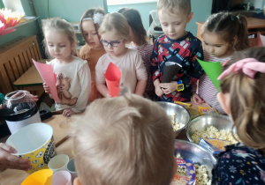 dzieci czekają w kolejce do popcornu