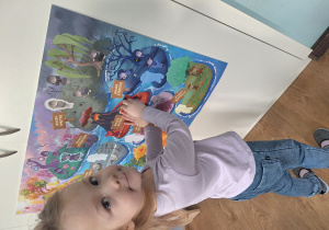 dziewczynka przykleja czuciaka na plakat