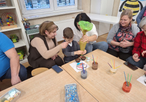 mama z synem nakłada krem na babeczkę