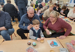 chłopiec dekoruje babeczkę