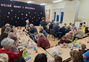 dzieci z dziadkami siedzą przy stole