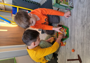 Chłopcy wspólnie układają kamienie.