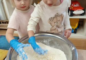 Dziewczynki wyrabiają ciasto z masy solnej.