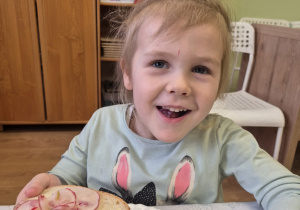 Dziewczynka prezentuje kanapkę z wędliną i rzodkiewką.