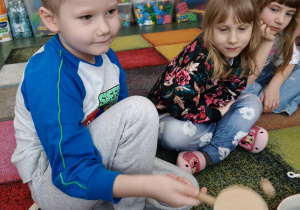 Chłopiec gra na instrumencie, według własnego pomysłu.