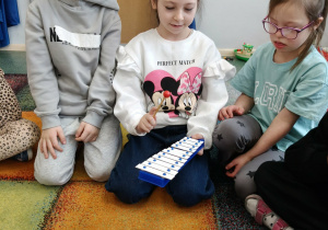 Dziewczynka gra na instrumencie, według własnego pomysłu.