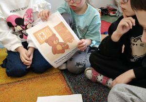 Dziewczynka omawia swój sposób na pomoc misiowi.