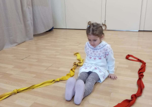 Dziewczynka wykonuje ćwiczenia ruchowe.