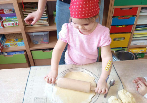 Dziewczynka wałkuje ciasto.