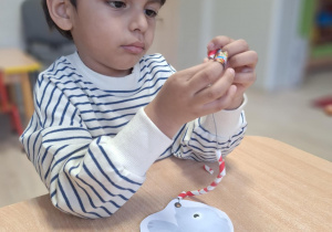 chłopiec nawleka słomki