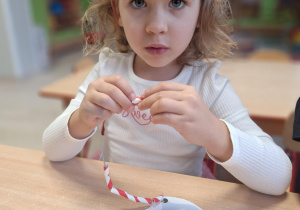 Dziewczynka nawleka słomki