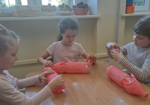 Dzieci wykonują papierowe ogonki.