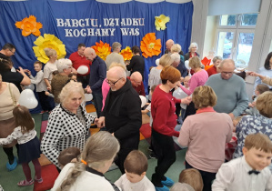 Dzieci tańczą ze swoimi dziadkami.