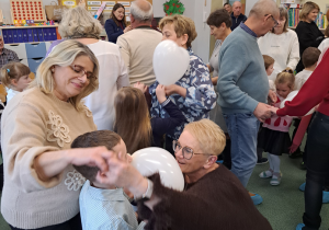 Dzieci tańczą ze swoimi dziadkami.