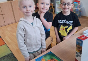 Chłopcy prezentują ułożone puzzle.