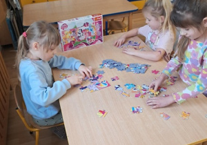 Dziewczynki układają puzzle.