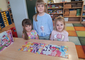 Dziewczyny prezentują ułożone puzzle.