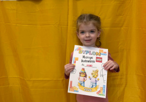 Hania pozuje z dyplomem mistrza budowania