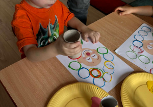 Olek wykonuje pracę plastyczną przy stoliku