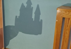 na ścianę rzucany jest cień zamku