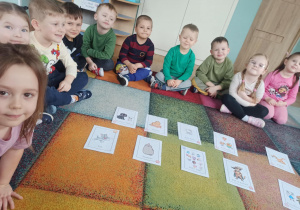 dzieci siedzą na dywanie