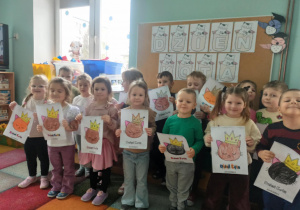 dzieci pozują do zdjęcia z kolorowankami