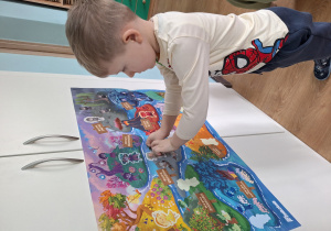 chłopiec nakleja czuciaka na plakat