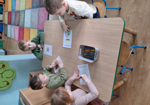 dzieci tworzą obrazek z narysowanego konturu pudełka