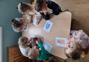 dzieci tworzą obrazek z narysowanego konturu pudełka