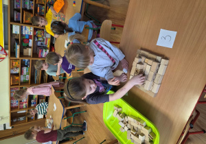 Hania B. i Hania Ł. budują piramidę z drewnianych sześcianów i prostopadłościanów.