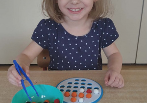 Układanie według wzoru kolorowych pomponów.