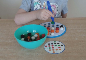 Układanie według wzoru kolorowych pomponów.