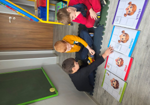 Dominik układa obrazek pod odpowiednia emocją.