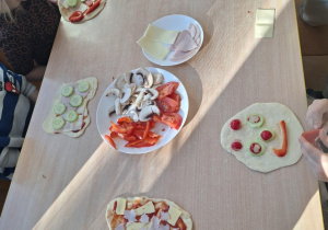 dzieci dekorują swoją pizze