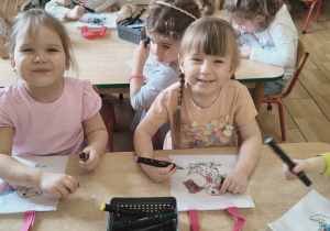 Dziewczynki kolorują torebki.