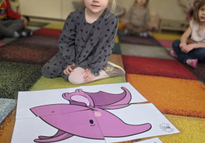 Dziewczynka układa puzzle.