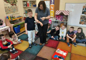 Nauczyciel tłumaczy zakładanie opatrunku na rękę.